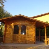 Una suggestiva casetta in legno illuminata dal sole al tramonto, con un accogliente portico e gradini di pietra