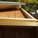 Primo piano della giuntura tra due pannelli di legno, mostrando la texture del legno e la sua finitura naturale di colore chiaro